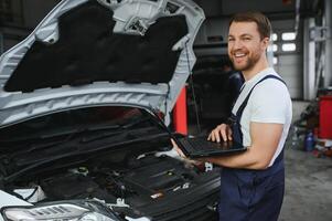 coche mecánico utilizando un computadora ordenador portátil a diagnosticando y comprobación arriba en coche motores partes para fijación y reparar foto