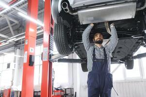 auto mecánico trabajando a auto reparar tienda foto