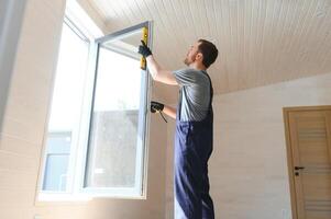 Construction worker installing new window in house photo