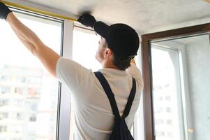 The foreman installs a window frame in the room photo