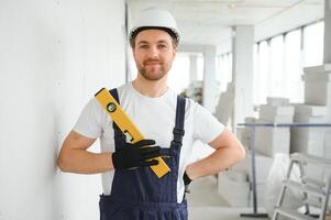 Portrait of positive, handsome young male builder in hard hat. photo