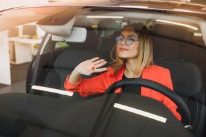 young woman looking in the rearview mirror of a car photo