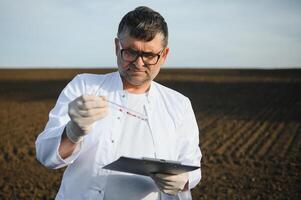 especialista comprobación calidad de suelo antes de plantando y otro mano participación cuaderno y bolígrafo. concepto suelo mejora para agricultura foto