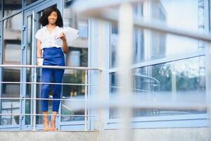 business black woman holding a cup of coffee and files photo