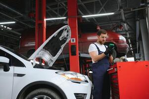 auto mecánico trabajando en coche motor en mecánica cochera. reparar servicio. foto