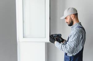 trabajador de la construcción instalando ventana en casa foto