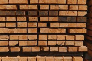 Stack of lumber of a wooden board from a tree, close-up, background. Wooden boards at the sawmill, carpentry workshop. Sawing and air drying of wood. Woodworking industry. Wooden boards photo