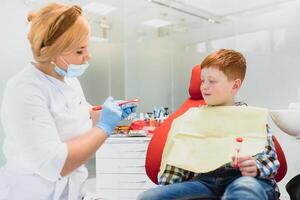 pequeño chico teniendo su dientes examinado por un dentista foto