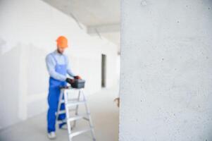 building, protective gear and people concept - builder carrying toolbox at construction site photo