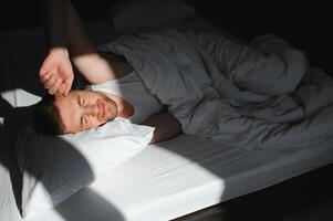 Man in sleeping bed, morning time. photo