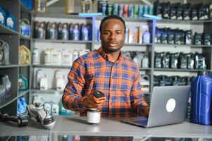 Portrait of a handsome african salesman in an auto parts store. The concept of car repair photo