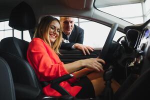 business woman buys a car at a car dealership. Concept of happy business people photo