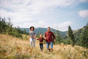 Young family with child resting on a mountain photo