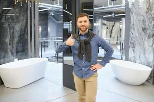 Young man choosing a bath and bath sink photo