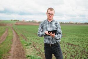 happy farmer in the fields with a laptop computer photo