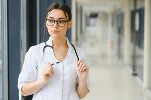 Happy young female doctor wear uniform, white medical coat, stethoscope. Portrait of beautiful female doctor, therapist, nurse. photo