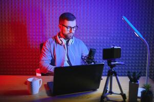 A video blogger records content in his studio. The backstage photo was taken from behind one of the participants in the shooting, at the beginning of the shooting when the blogger is preparing.