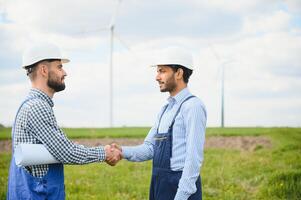 joven mantenimiento ingeniero equipo trabajando en viento turbina granja. foto