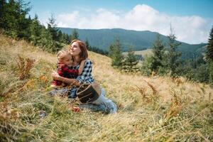 Mom hugs a little son at the top of the mountain. Square. The concept of family, yoga, travel. photo