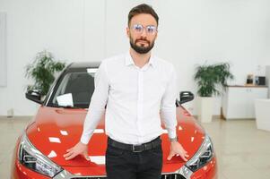 un hombre examina un coche en un coche concesión foto