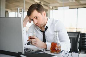 Young businessman drinking from stress photo