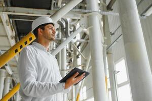 happy male industrial technician inside a factory photo