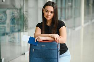 vacaciones viajar. hermosa joven morena dama en aeropuerto Terminal, contento sonriente milenario dama Listo para fiesta viaje, yendo a salida puerta, Copiar espacio. foto