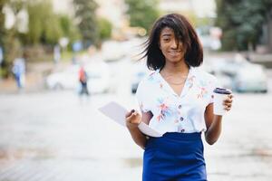 business black woman holding a cup of coffee and files photo