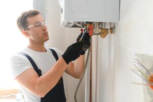 Professional plumber checking a boiler and pipes, boiler service concept photo