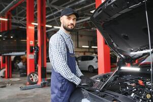 Professional car mechanic working in auto repair service. photo