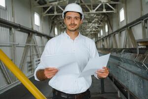 happy male industrial technician inside a factory photo