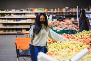 African american woman with shopping cart trolley in the supermarket store photo