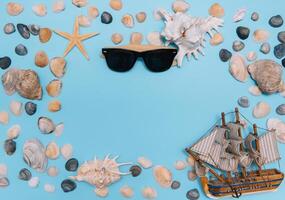 Flat lay. Top view. Frame of shells of various kinds on a blue background. Seashells and starfish and ship on a pastel background. Vacation concept. travel concept. with copy space photo