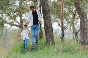 contento padre y pequeño chico caminando en verano parque. adopción y personas concepto. foto