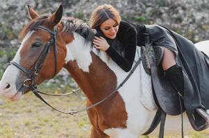 Portrait of young pretty cheerful woman with horse at summer photo