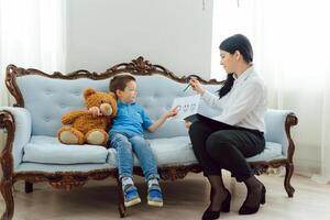 Child psychologist working with boy in office photo