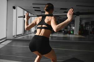 hermosa mujer es haciendo ejercicios con Deportes palo foto