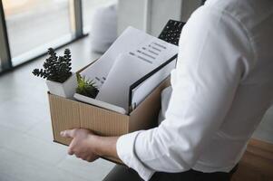 Close-up Of A Businessperson Carrying Cardboard Box During Office Meeting photo