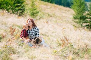 Mom hugs a little daughter at the top of the mountain. Square. The concept of family, yoga, travel photo