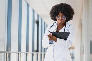 hermosa africano americano hembra pediátrico enfermero en moderno oficina foto