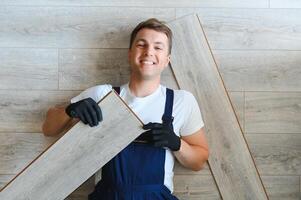 hombre instalando nuevo laminado de madera piso foto