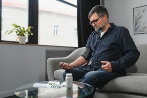 Senior man using medical device to measure blood pressure photo