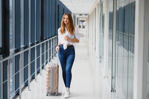 joven, hembra pasajero a el aeropuerto, esperando desesperadamente para su retrasado vuelo foto