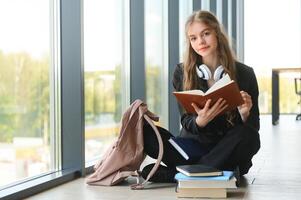 education and school concept - student girl studying and reading book at school. photo