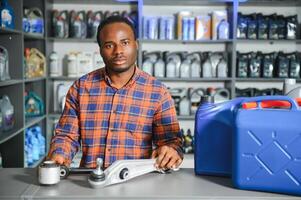 seller man with canister of motor oil in auto store photo