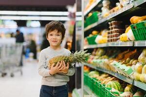 pretty boy with pineapple in supermarket photo