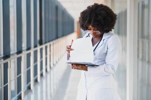 healthcare and medical concept - african doctor holding syringe with injection photo