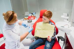 chico satisfecho con el Servicio en el dental oficina. concepto de pediátrico dental tratamiento foto