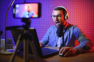 A video blogger records content in his studio. The host of the video blog is a young man who is very enthusiastic about telling his subscribers a story. photo