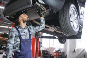 Auto mechanic working at auto repair shop photo